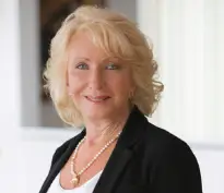 Diane Portnoy, a woman with blonde hair and wearing a dark blazer and white shirt.