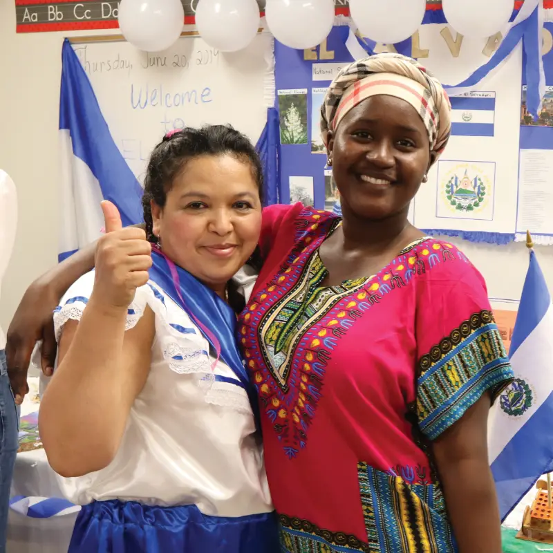 two smiling women with a thumbs up