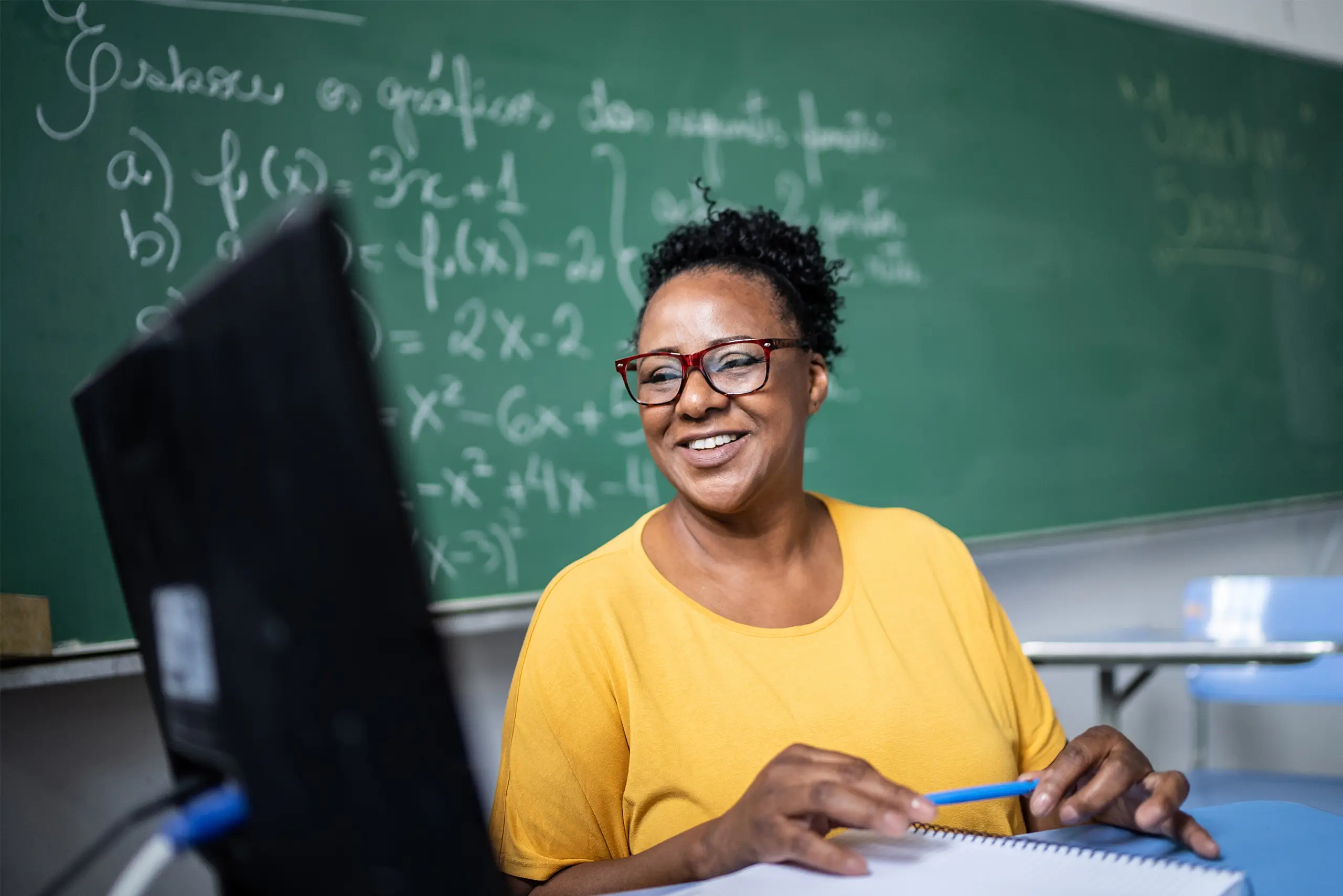 Teacher in a classroom looking at a computer screen