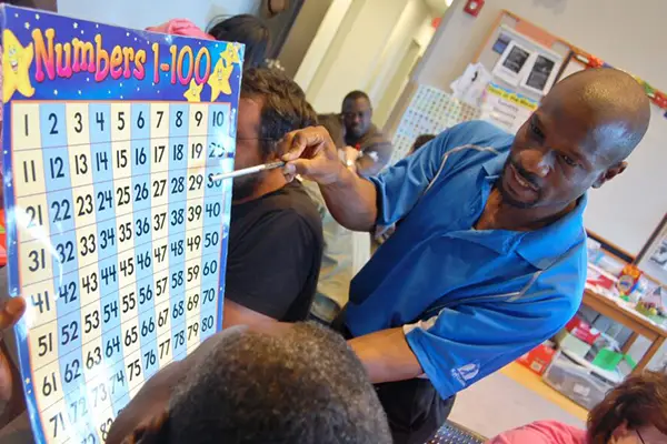 Teacher showing a number chart to students